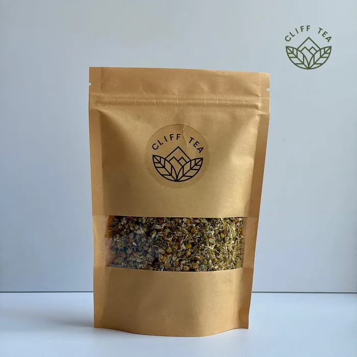 Whole dried chamomile flowers beside a cup of golden chamomile tea