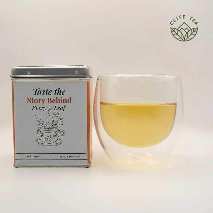 Whole dried chamomile flowers beside a cup of golden chamomile tea