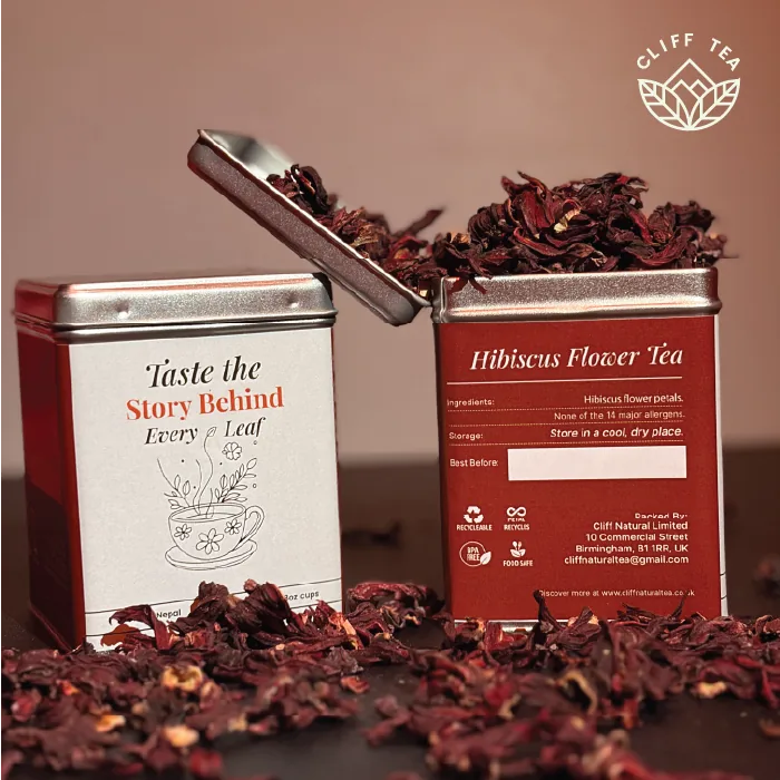 Whole dried hibiscus flowers next to a cup of deep red hibiscus tea